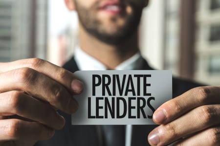 Man holding a sign saying "private lending"