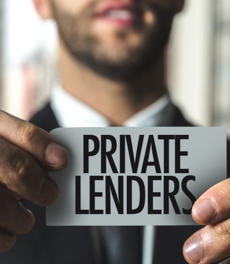 Man holding a sign saying "private lending"